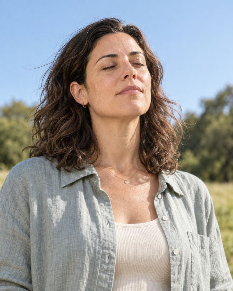 The woman from the opening, outdoors with her eyes closed, breathing easily.